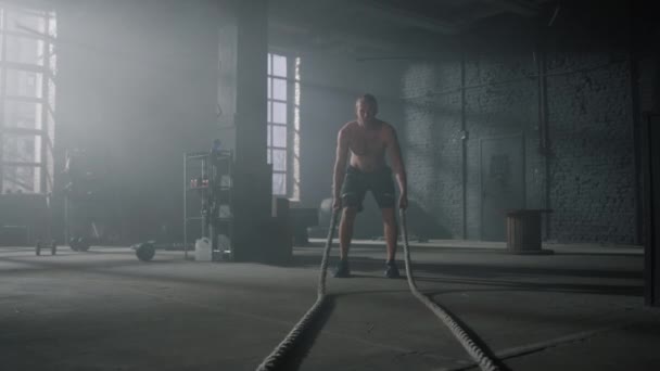 Hombre practicando ejercicio con cuerdas de batalla. Deportista haciendo entrenamiento funcional — Vídeos de Stock