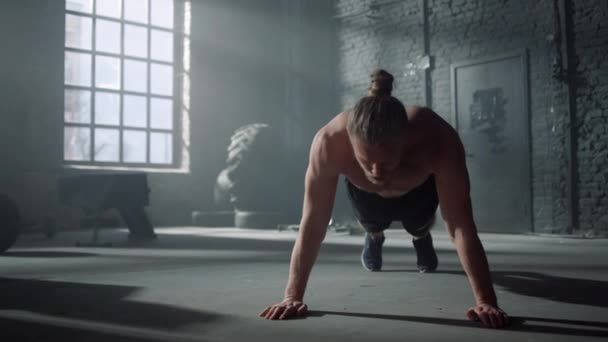 Hombre fuerte teniendo desafío deportivo en el gimnasio. Hombre atleta haciendo flexiones en el suelo — Vídeo de stock