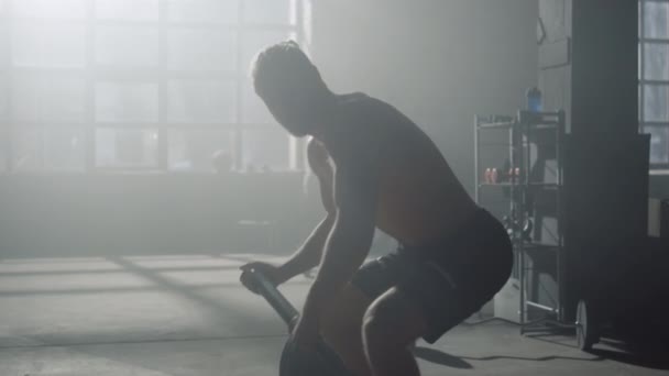 Спортсмен заканчивает фитнес-тренировку с гирями. Парень держит штангу в спортзале — стоковое видео