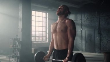 Spor salonunda halter kaldıran adam. Vücut geliştirici geniş tutuş biceps kıvrım egzersizi yapıyor