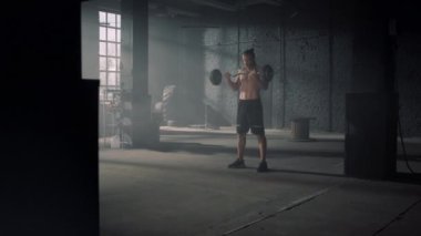 Atletik adam ağırlık kaldırıyor. Powerlifter geniş tutuş biceps kıvrım egzersizi yapıyor