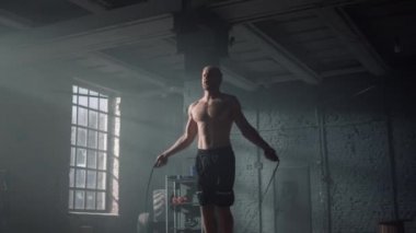 Spor kulübünde ip atlama egzersizi yapan bir adam. Atlayan sporcu ip atlıyor.