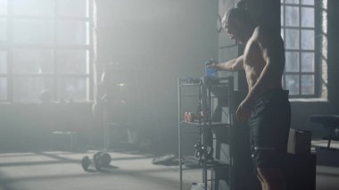 Elinde su olan bir adam. Sportif adam antrenmandan sonra dinleniyor.