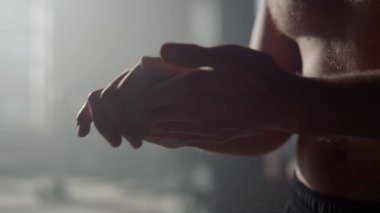 Sporcu talk pudrasıyla el çırpıyor. Egzersizden önce magnezyum kullanan adam