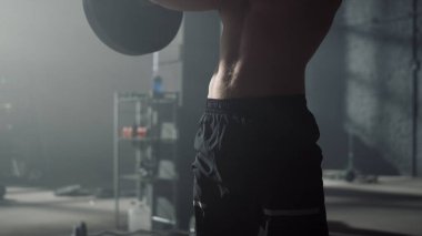 Koltuk değnekleriyle çömelen bir adam. Spor kulübünde ağırlık kaldıran erkek sporcu