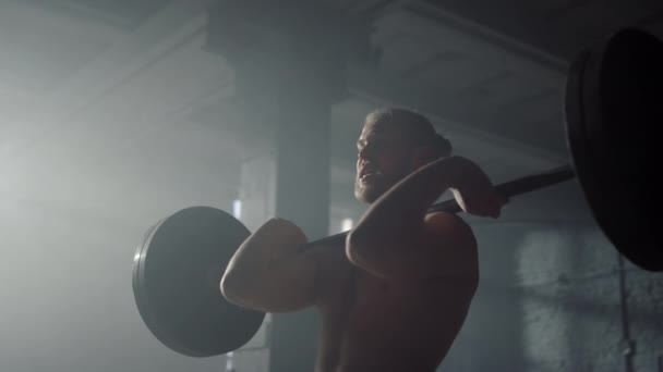 Powerlifter hefgewichten in de sportschool. Man met zware lange halter op de schouders — Stockvideo