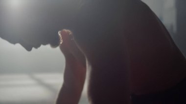 Spor salonunda duran ciddi bir adam. Atletik adam antrenmana hazırlanıyor.