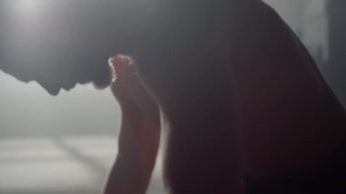 Spor salonunda duran ciddi bir adam. Atletik adam antrenmana hazırlanıyor.