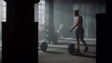 Genç sporcu spor kulübünde halter kaldırmadan önce ağırlık kontrolü yapıyor.