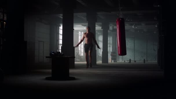 Male boxer jumping on skipping rope. Man with naked torso using jump rope — Stock Video