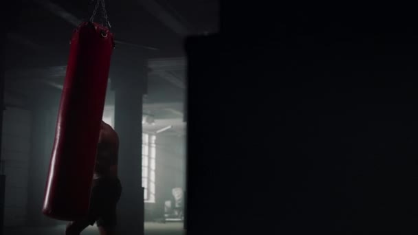 Hombre afroamericano boxeando saco de boxeo en gimnasio. Sportsman perforando bolsa de deporte — Vídeos de Stock