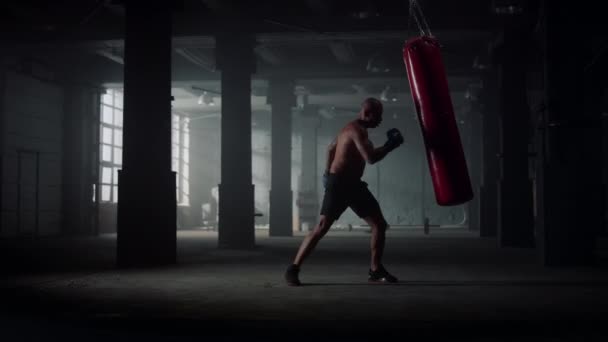 Boxeador masculino saco deportivo de boxeo. Hombre enojado trabajando golpes en saco de boxeo — Vídeos de Stock