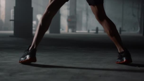 Patas de hombre moviéndose durante el entrenamiento. Hombre practicando kickboxing con saco de boxeo — Vídeo de stock