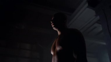 Spor salonunda duran erkek sporcu. Eğitimden sonra kaslı vücudu dinlenen Afro bir adam.