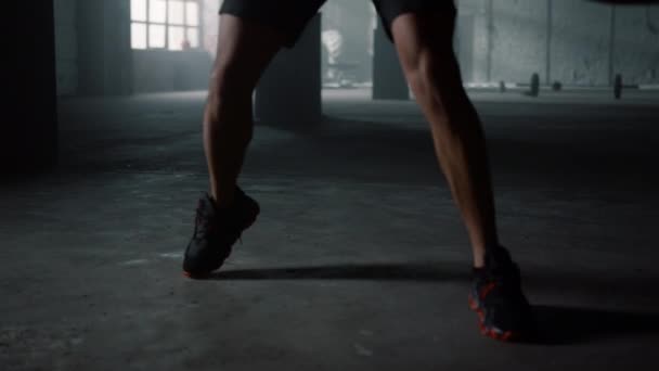 El hombre se mueve activamente durante el entrenamiento. Boxeo boxeador con saco de boxeo — Vídeos de Stock