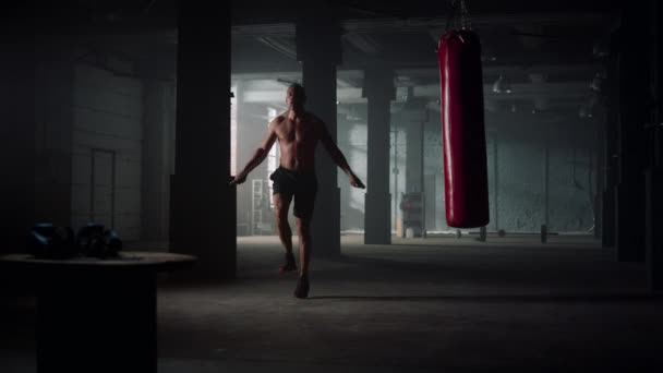 Hombre saltando con saltar la cuerda en el gimnasio. Deportista haciendo ejercicio cardiovascular — Vídeos de Stock