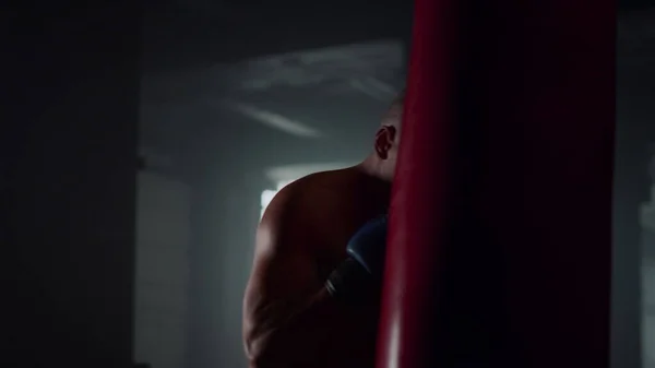 Man boxning boxningssäck i gymmet. Shirtless idrottsman kickboxning sportväska — Stockfoto