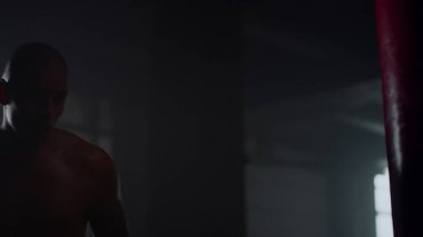 Spor salonunda yorgun adam boks torbası. Erkek boksör kardiyo çalışması yapıyor.