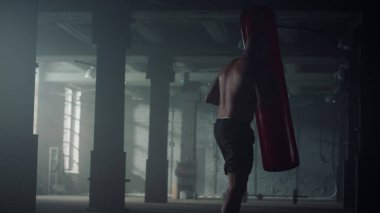 Kaslı adam boks torbası. Erkek boksör spor kulübünde kardiyo çalışması yapıyor.