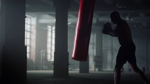 Esportista a treinar intensamente. Homem chutando saco de soco durante o treino de boxe — Fotografia de Stock