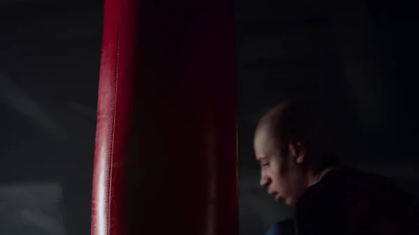 A bokszzsákot gyakorló bokszoló tornateremben. Dühös férfi boksz sport táska — Stock Fotó