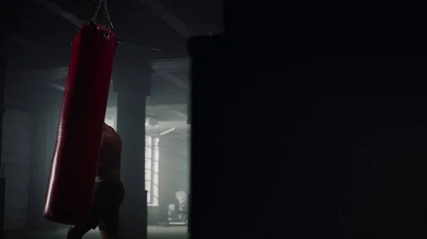 Африканский американец боксер боксерская груша в спортзале. Спортсмен бьет спортивную сумку — стоковое фото