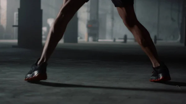 Boks antrenmanı sırasında erkek bacakları hareket ediyor. Kickboks antrenmanı yapan adam kum torbasıyla — Stok fotoğraf