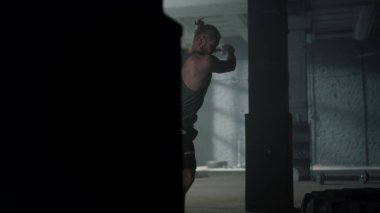 Lastiğe çekiçle vuran bir adam. Güçlü adam balyozla egzersiz yapıyor.