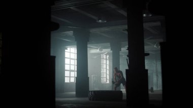 Çatı katında erkek eğitimi. Aktif sporcu çekiçle lastik lastiğe vuruyor.