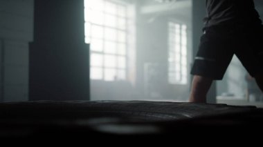 Lastiğe çekiçle vuran bir adam. Balyozla egzersiz yapan adam.