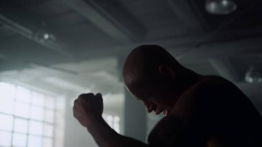 Sporcu antrenman sırasında el sürüşü talimi yapıyor. Adam kardiyo çalışması yapıyor.