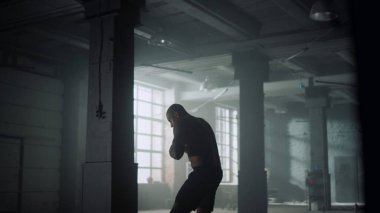 Boksör antrenman sırasında tekme pratiği yapıyor. Spor kulübünde boks yapan bir adam.