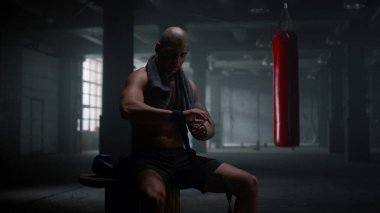 Boksör elleri boks kasetlerine sarıyordu. Yumruk sargıları kullanan odaklanmış sporcu 