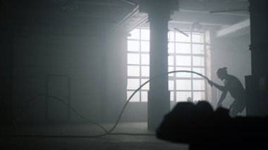 Spor salonunda idman yaparken halat kullanan bir adam. Crossfit egzersizi yapan bir atlet