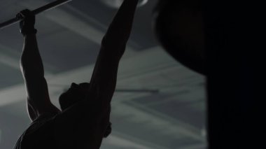 Sporcu barın üstünde barfiks çekiyor. Formda adam vücudunun üst kısımları için egzersiz yapıyor.