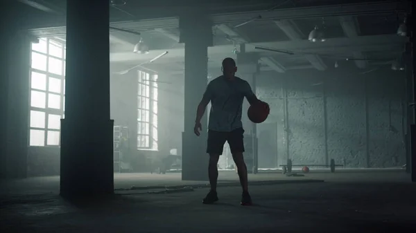 Basketballspieler beim Training im Sportverein. Sportlicher Mann dribbelt Ball zwischen den Beinen — Stockfoto