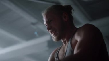 Vücut geliştirici halatlarla savaşıyor. Sporcu savaş halatlarıyla antrenman yaparken çığlık atıyor.