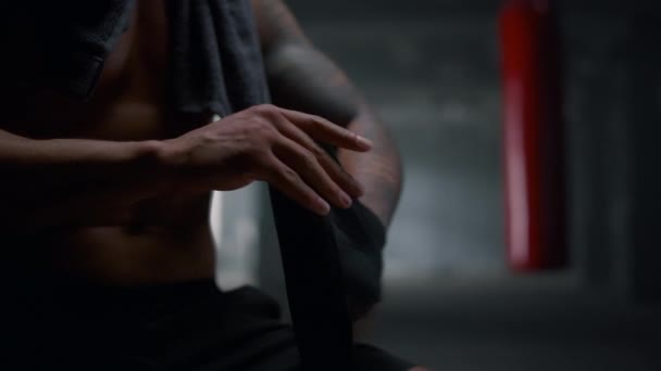 Boxer lyukasztópapírt használ tornateremben. Férfi csomagoló kéz boksz szalagokkal — Stock videók