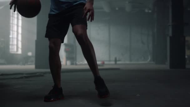 Man bouncing basketball ball between legs. Male player playing basketball — Stock Video