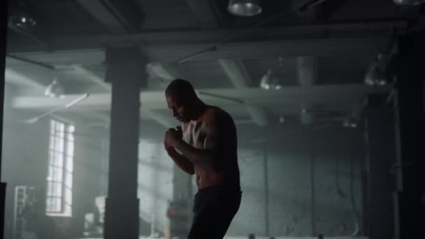 Han övar kickboxning på gymmet. Guy träning slag under cardio träning — Stockvideo