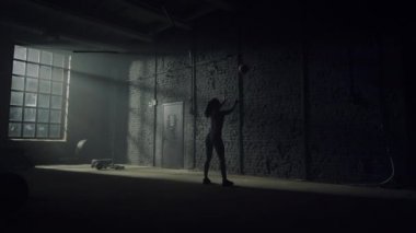 Duvara karşı topla çömelen bir kadın. Vücut geliştirici Crossfit egzersizi yapıyor