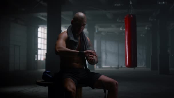 Boxer che avvolge le mani in nastri da boxe. Sportivo concentrato che utilizza involucri di punzonatura — Video Stock