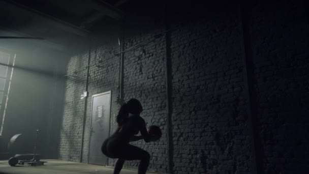 Mujer haciendo sentadillas con pelota pesada. Chica lanzando bola en forma contra la pared — Vídeos de Stock