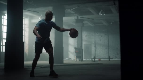 Man having basketball training in loft building. Player bouncing basketball ball — Stock Video