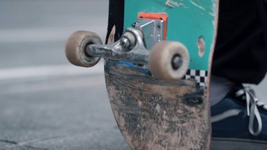 Dışarıda kaykay tutan bir adam var. Bilinmeyen adam dışarıda kaykay yapmaktan hoşlanıyor..