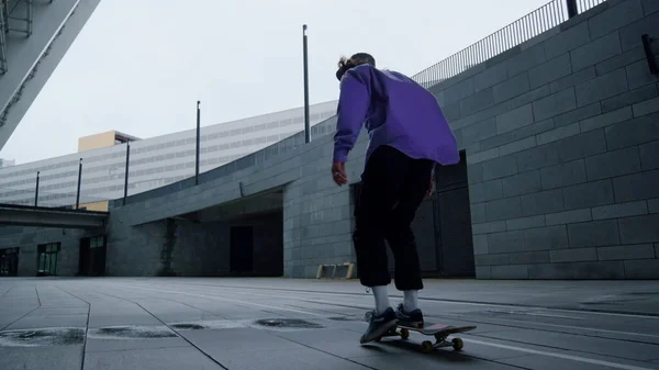 Patinador montando en la calle. Skateboarder entrenamiento al aire libre en la mañana. — Foto de Stock