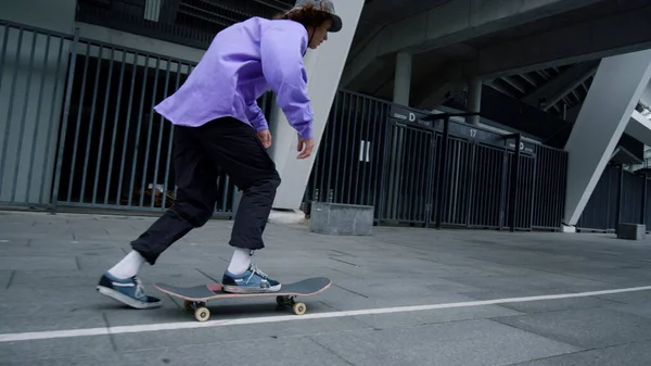 Mladý muž používá skateboard venkovní. Stylové hipster vyvažování na palubě venku. — Stock fotografie