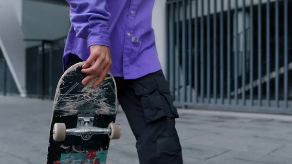 Onherkenbaar schaatser paardrijden buiten. Man voeten springen op skateboard op straat. — Stockfoto