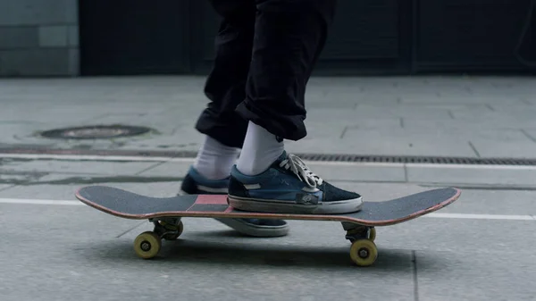 Onherkenbare man voeten balanceren op skateboarden op de stad straat closeup. — Stockfoto