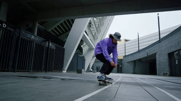 Aktives Hipsterspringen auf dem Skateboard im Freien. Skater balanciert auf Longboard. — Stockfoto